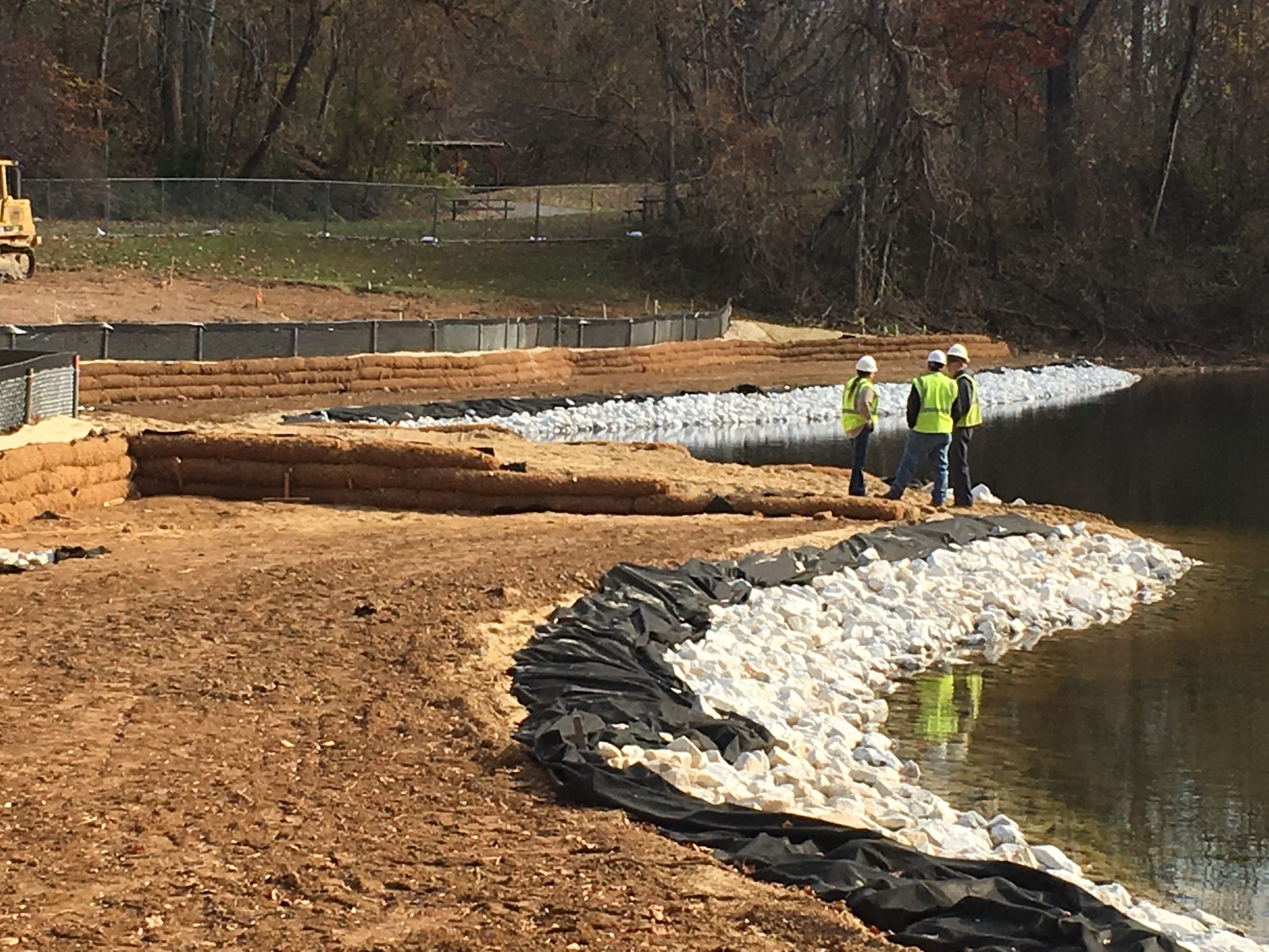 Construction crews standing near a water retention pond