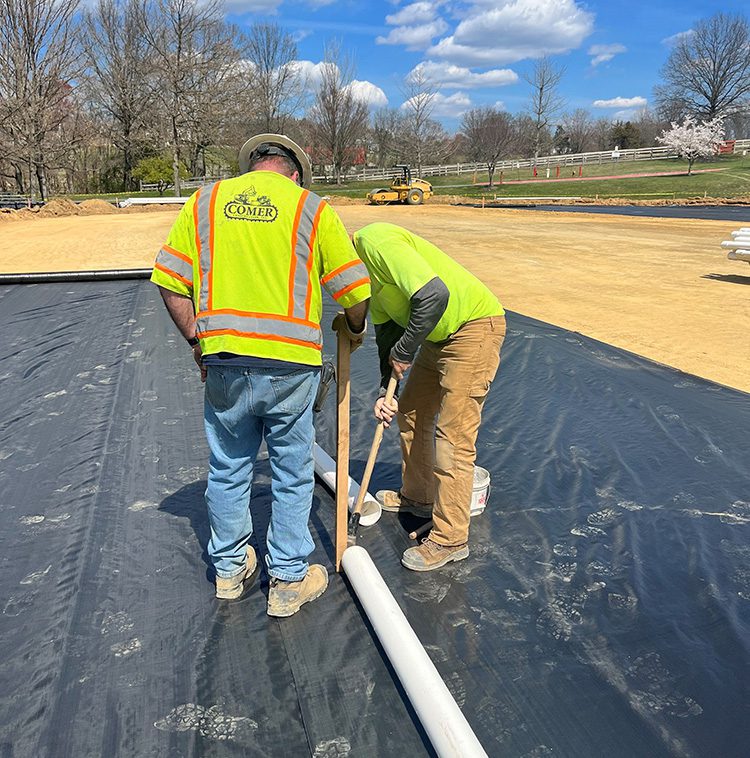 Worker installing speciality drainage system in Howard County, Maryland