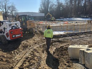 Comer Construction team member walking the construction site of a new pool