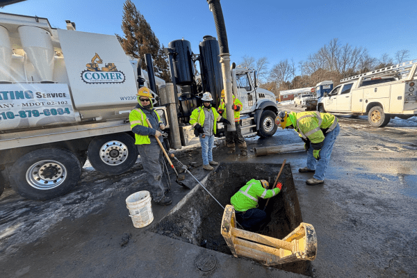 Construction crews using hyrdo excavation to access a broken water main and repair it.