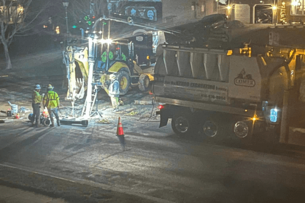 Comer construction crews repairing a water main in the middle of the night using hydro excavation.