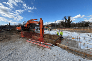 Excavator digging in a trench box