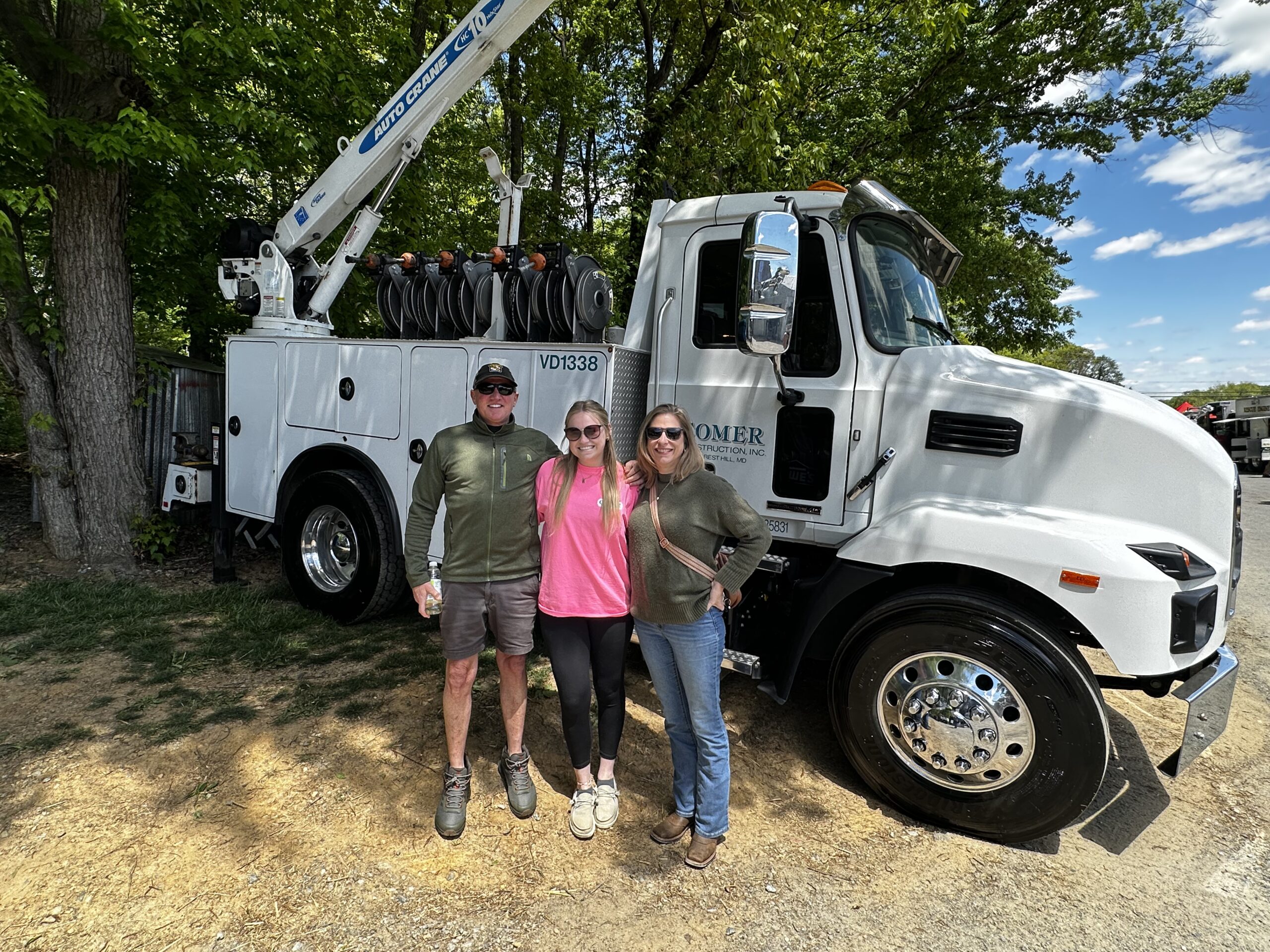 posing outside of Comer Construction booth at touch a truck