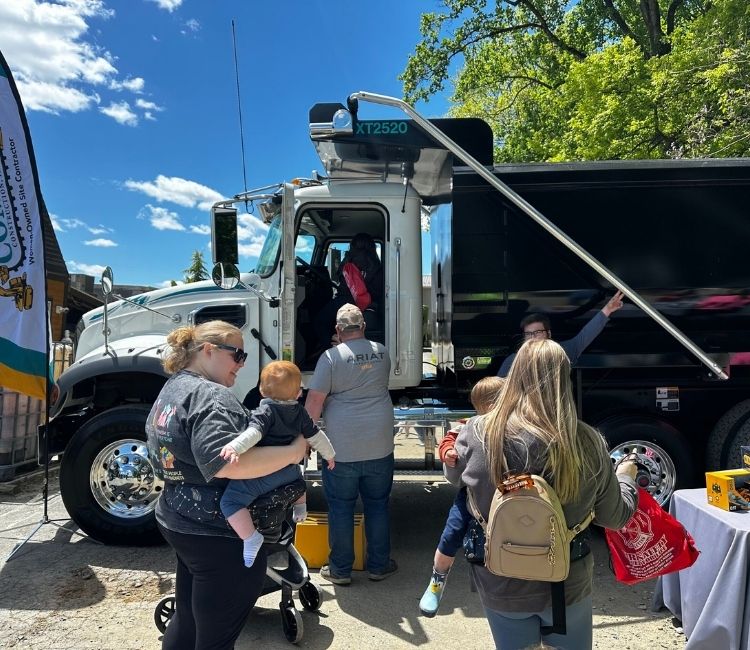 Families exploring a Comer Construction truck at the brewery event.