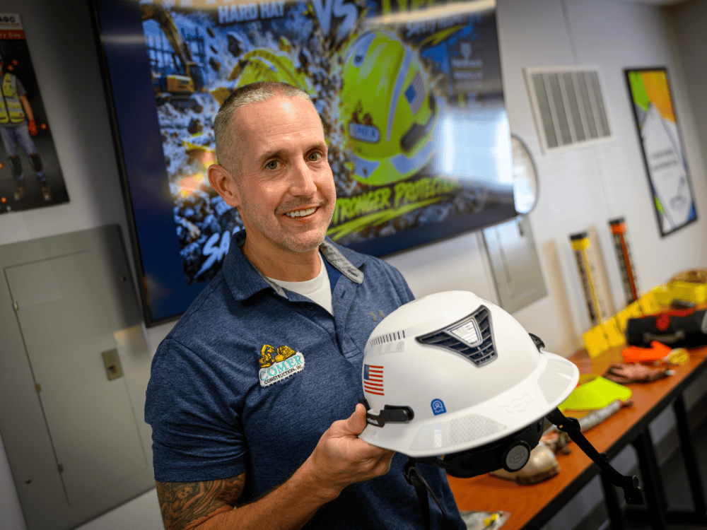 Tim holds one of the Type II safety helmets now worn by Comer