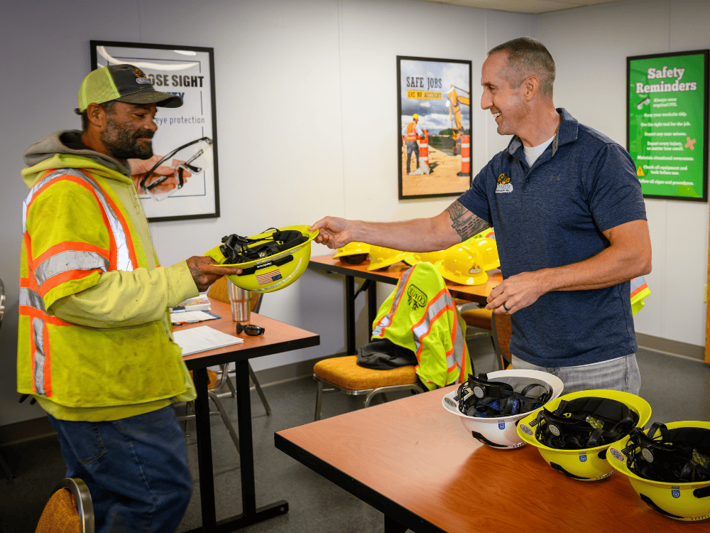A Comer Construction crew member receives a new Type II safety helmet during the switch from traditional hard hats.